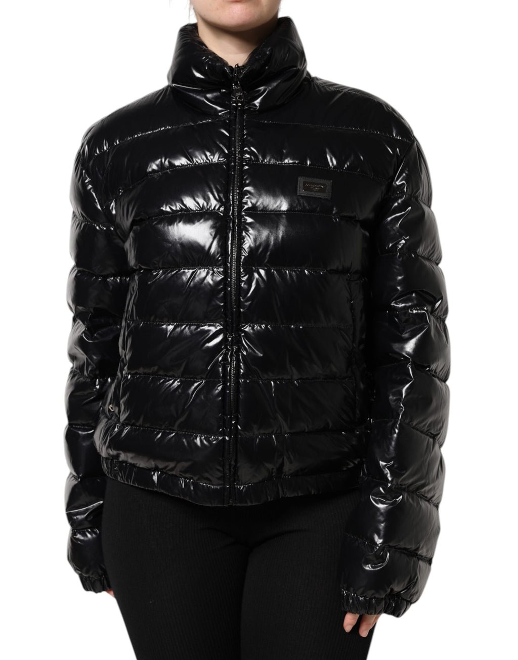 Veste matelassée noire Dolce & Gabbana avec logo en plaque, fermeture éclair complète et style élégant.