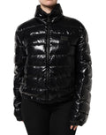 Veste matelassée noire Dolce & Gabbana avec logo en plaque, fermeture éclair complète et style élégant.