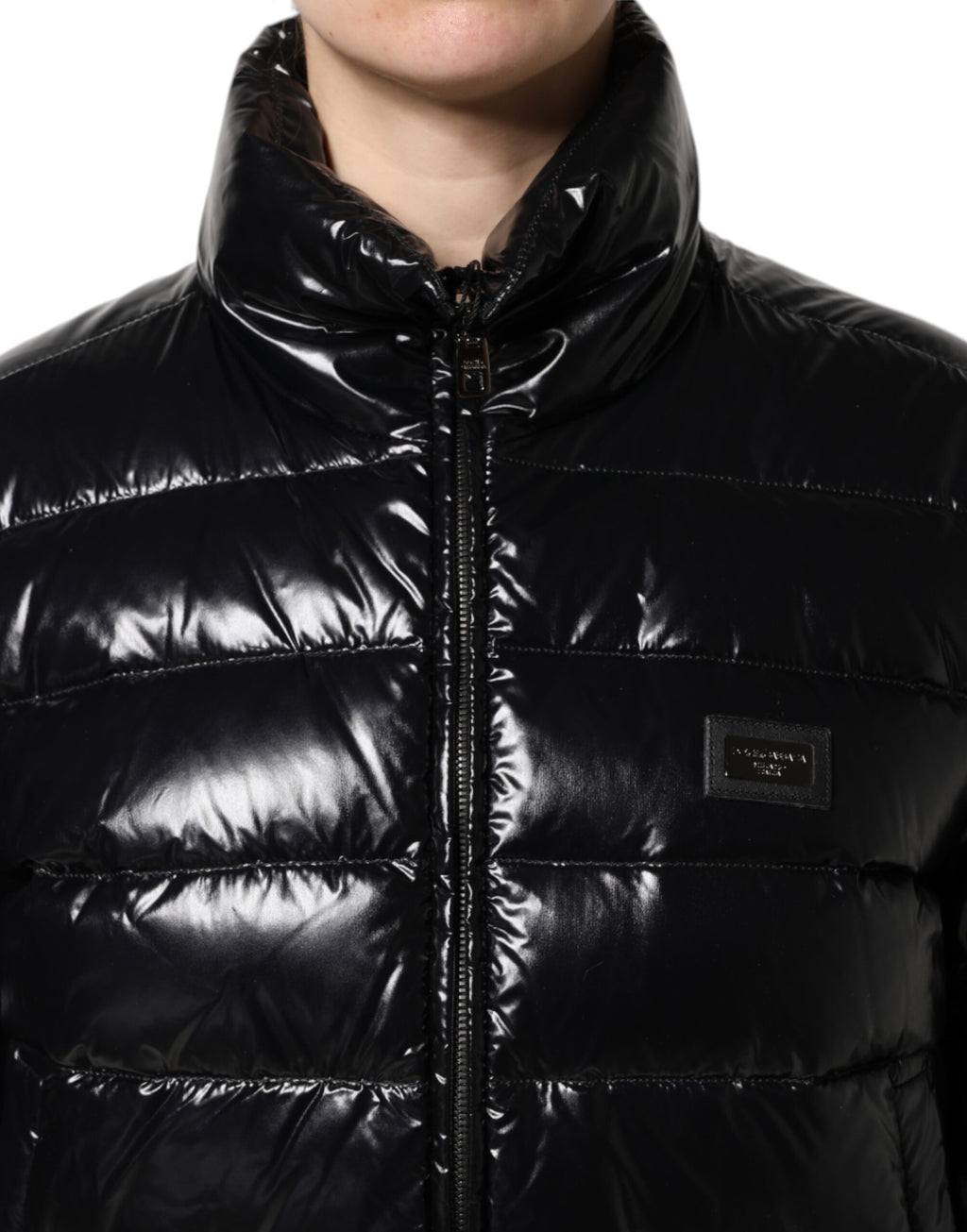 Veste matelassée noire Dolce & Gabbana avec logo en plaque, fermeture éclair pleine longueur, style chaud et élégant.