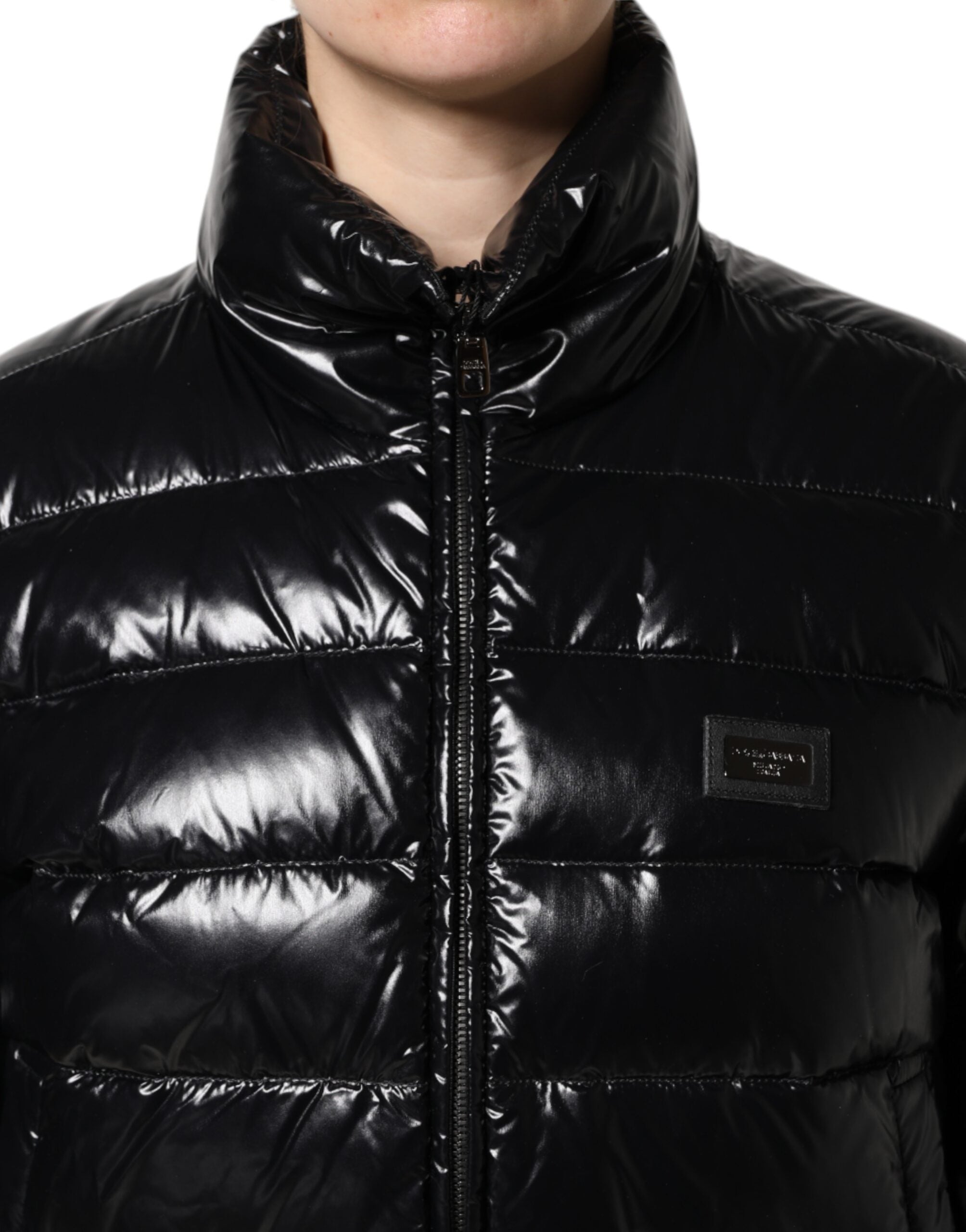 Veste matelassée noire Dolce & Gabbana avec logo en plaque, fermeture éclair pleine longueur, style chaud et élégant.
