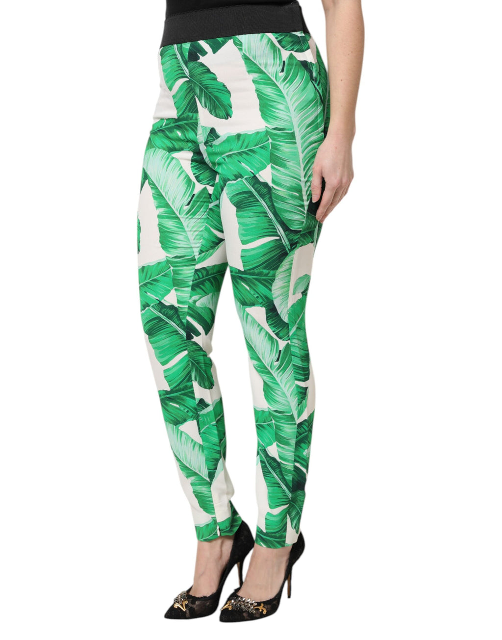 Pantalon taille haute Dolce & Gabbana blanc avec motif de feuilles vertes, élégant et tendance, visible en gros plan.