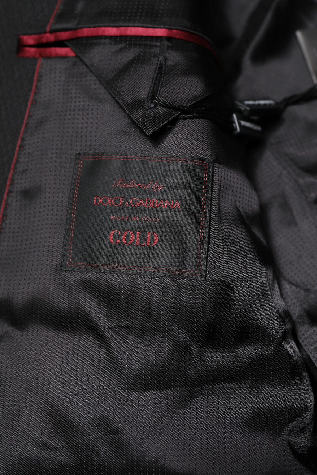 Costume noir Dolce & Gabbana pour homme avec veste blazer à un bouton, or brillant, coupe classique, tissu élégant.