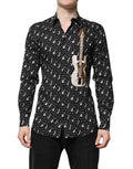 Chemise noire Dolce & Gabbana avec embellissements dorés et instruments, détails élégants et sophistiqués visibles sur l'image.