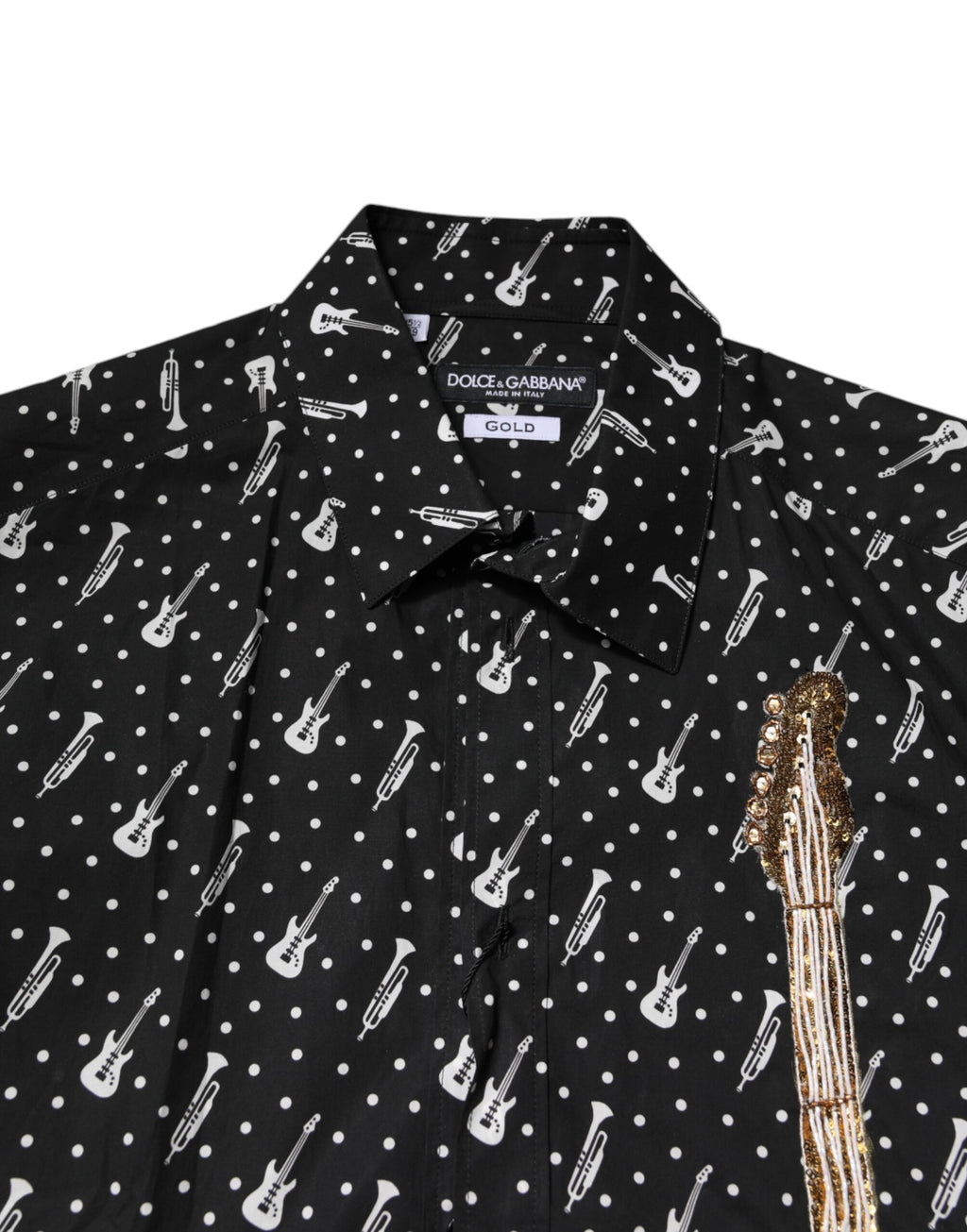 Chemise noire Dolce & Gabbana avec embellissements dorés et ornement d'instrument, élégante et sophistiquée.