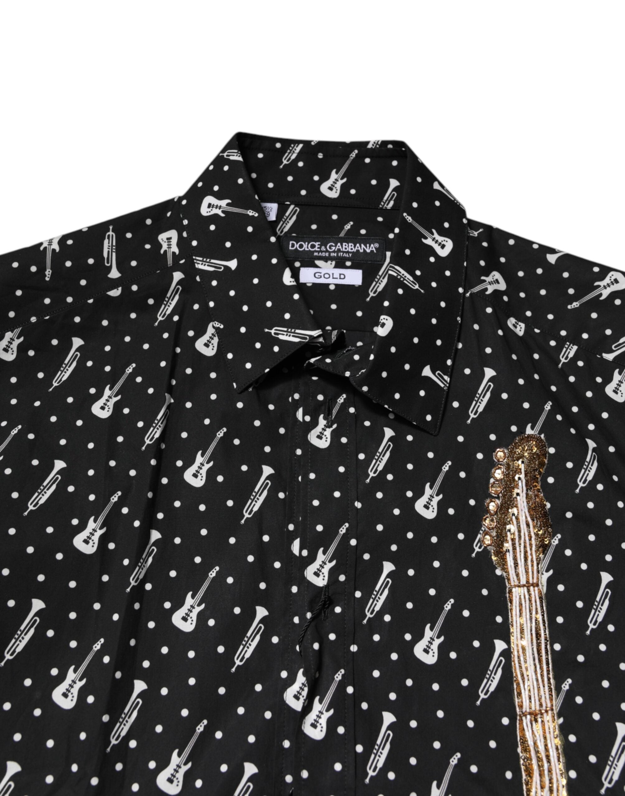 Chemise noire Dolce & Gabbana avec embellissements dorés et ornement d'instrument, élégante et sophistiquée.