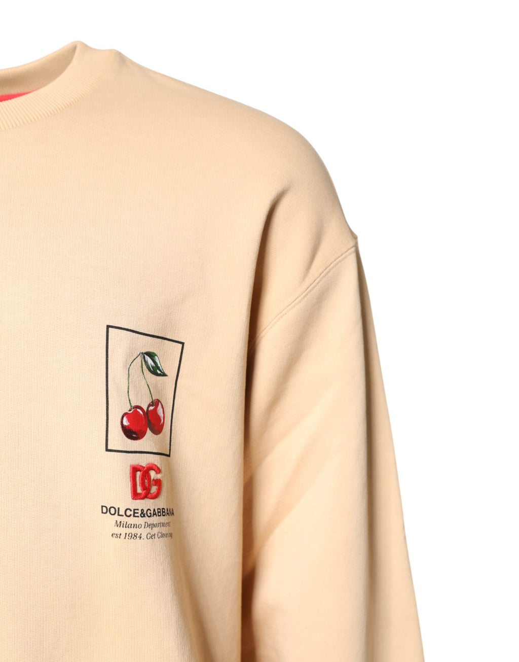 Pull-over Dolce & Gabbana beige avec motif cerises, col rond, en maille douce et élégante.