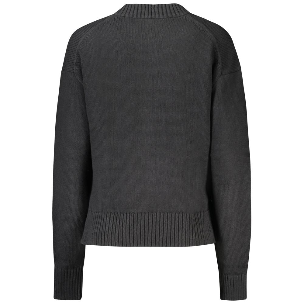 Pull femme noir en coton de la marque Calvin Klein, avec col rond et manches longues, porté sur un mannequin.