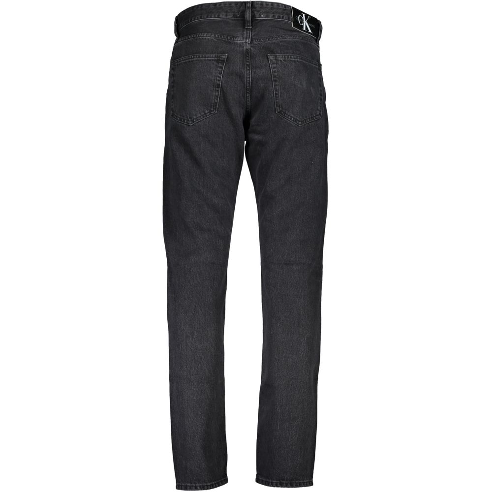 Jeans pour homme en coton noir de la marque Calvin Klein, coupe classique, détails de couture visibles.