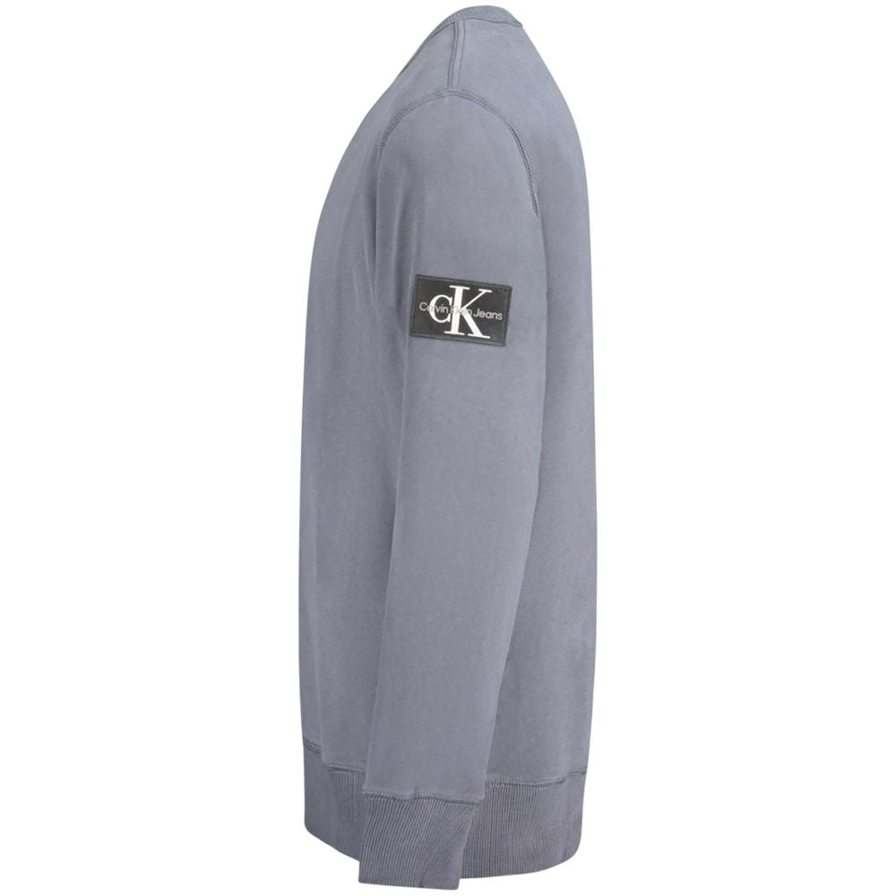 Pull homme en coton bleu Calvin Klein, style classique, avec col rond et manches longues, porté sur un modèle.