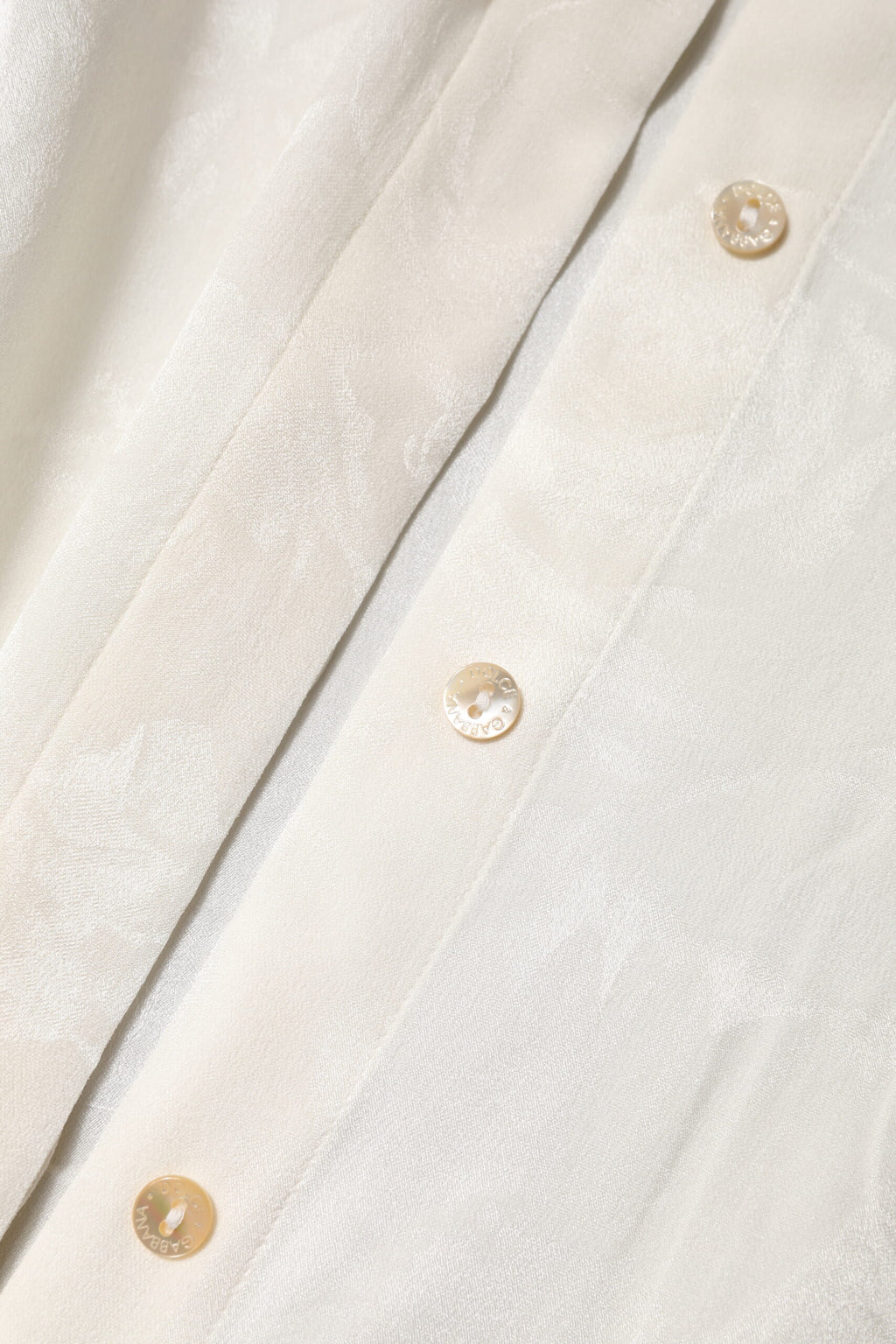 Blouse blanche à manches longues et boutons Dolce & Gabbana, élégante chemise en tissu léger et sophistiqué.