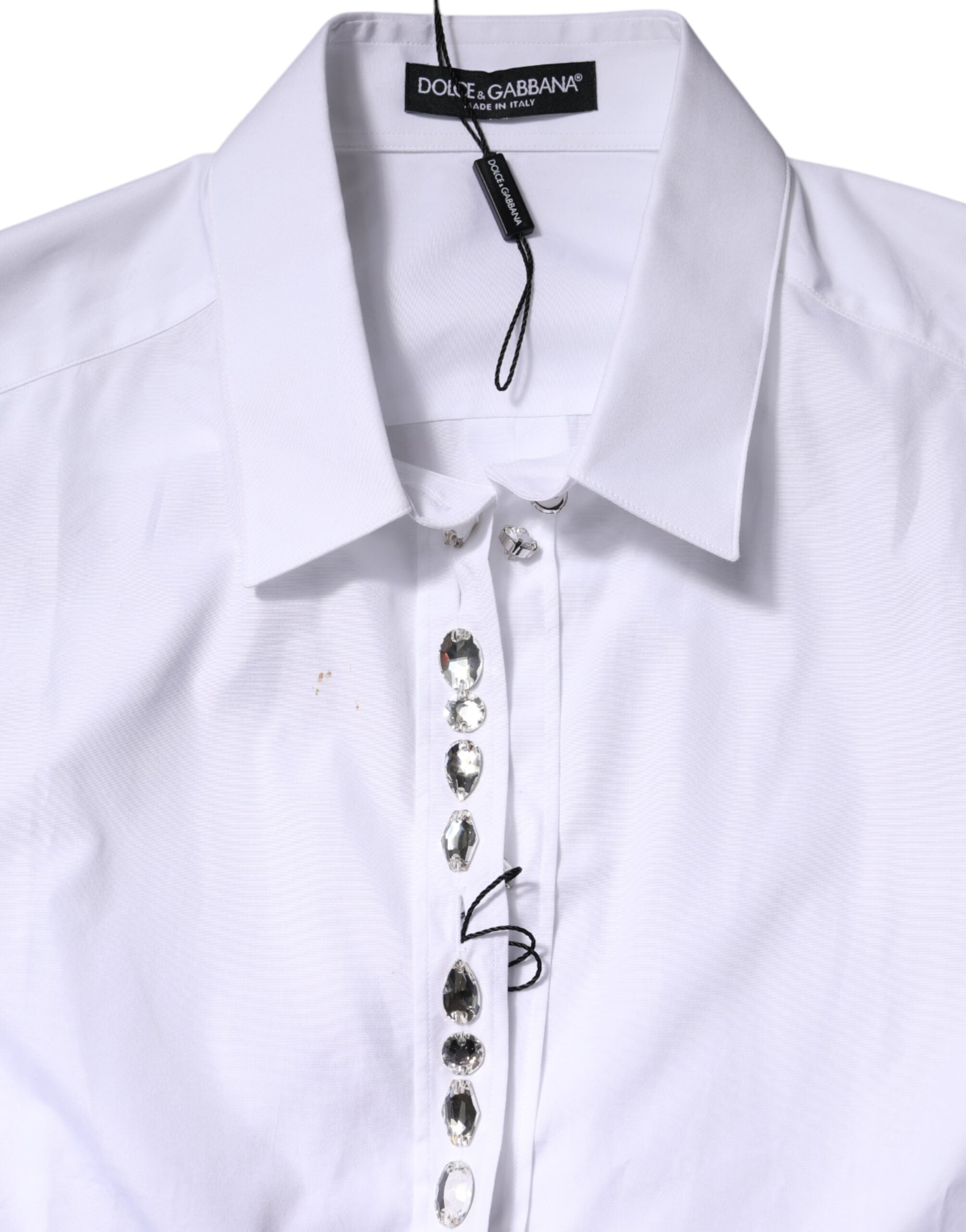 Top blanc Dolce & Gabbana à manches longues avec strass ornés et détails élégants, tissu léger et sophistiqué.