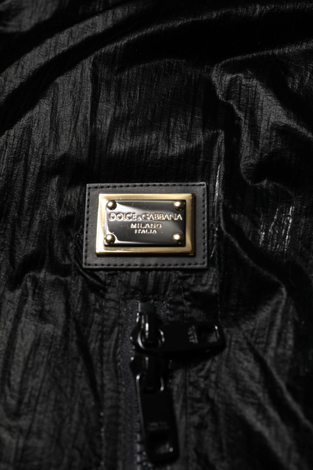 Veste matelassée noire à capuche avec logo Dolce & Gabbana, fermeture éclair complète, style décontracté et moderne.