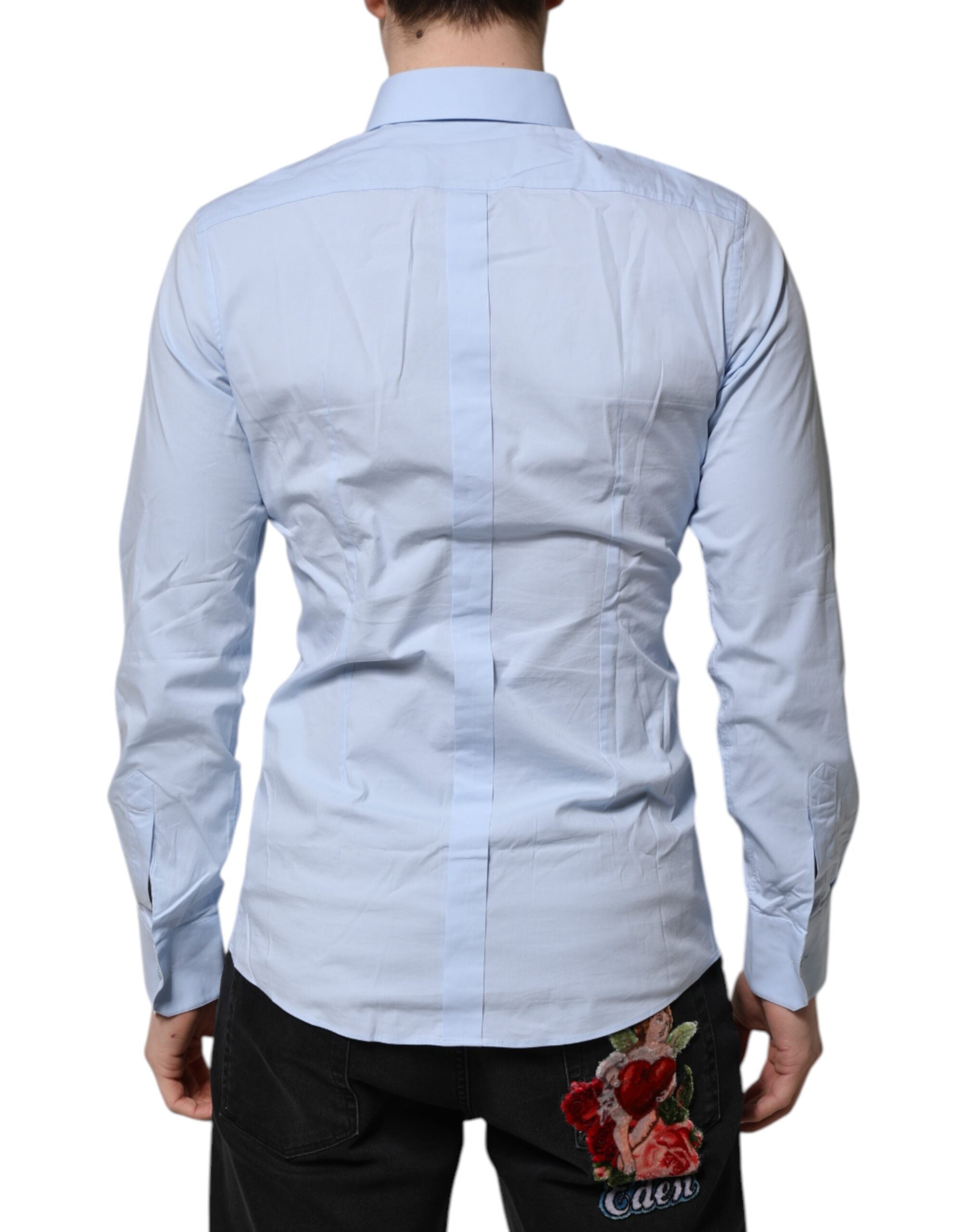 Chemise longue Dolce & Gabbana en coton bleu ciel à manches longues avec détails dorés, élégante et sophistiquée.