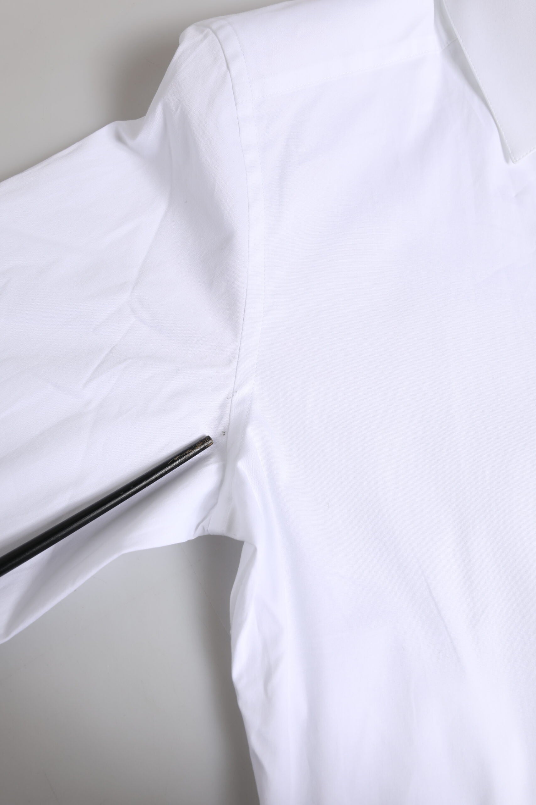 Chemise longue blanche en coton Dolce & Gabbana avec manches longues et détails dorés visibles sur l'image.