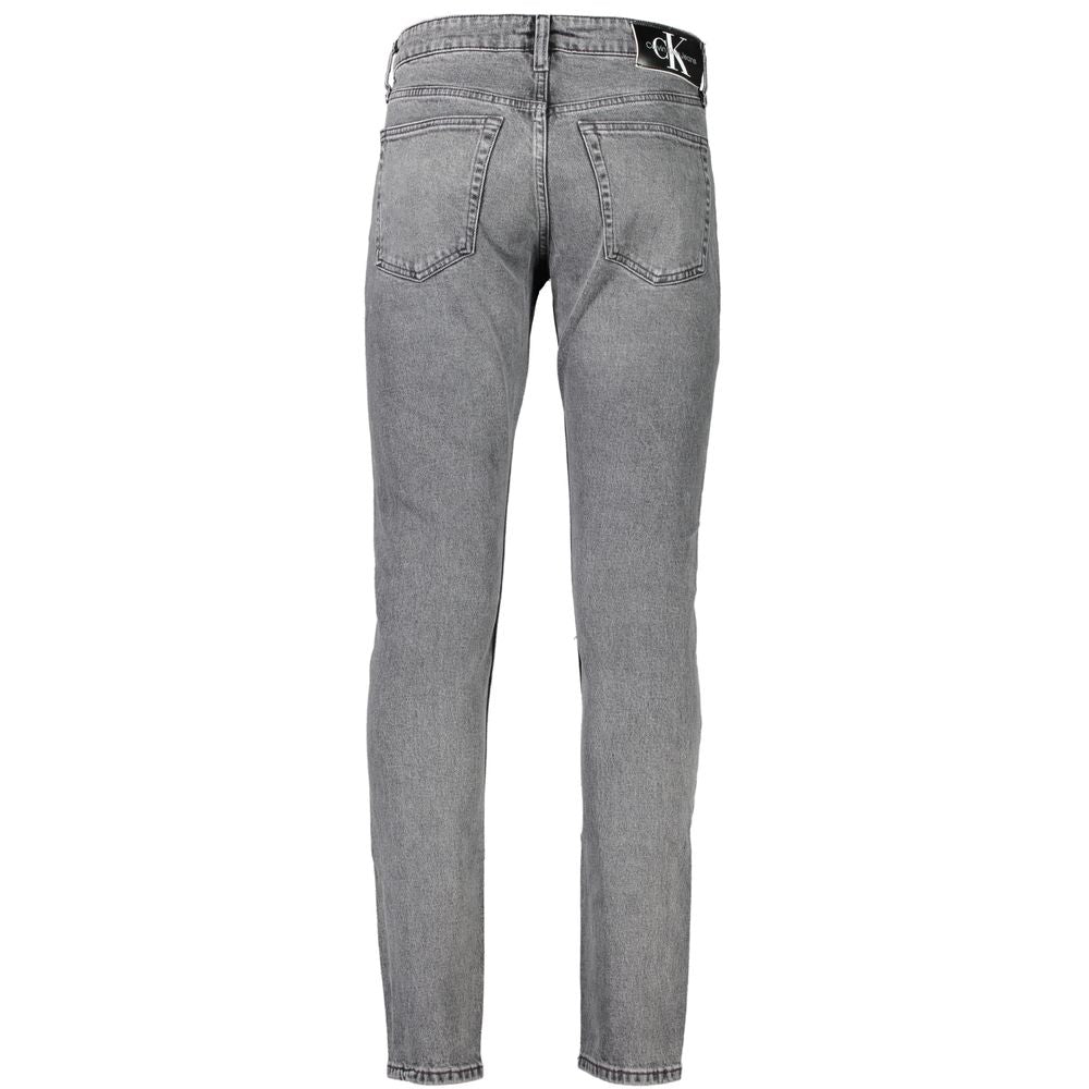Jean homme en coton gris Calvin Klein, coupe classique, détails de couture visibles, style décontracté et moderne.