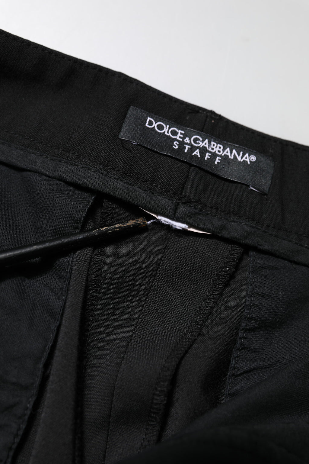 Pantalon noir Dolce & Gabbana taille haute et tapered, style élégant et moderne, en tissu fluide, porté sur un mannequin.