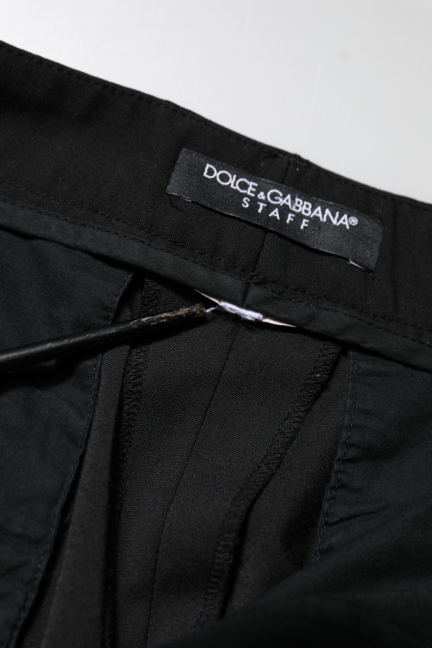 Pantalon noir Dolce & Gabbana taille haute et tapered, style élégant et moderne, en tissu fluide, porté sur un mannequin.
