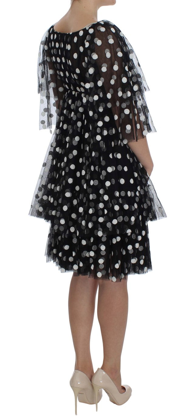 Robe à pois noire et blanche Dolce & Gabbana avec volants et détails élégants, parfaite pour une tenue sophistiquée.