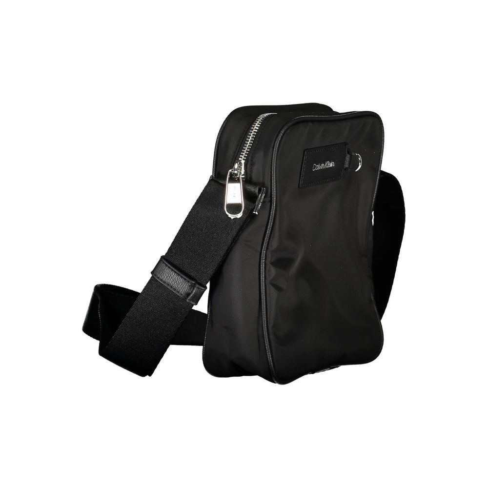 Sac à bandoulière pour homme Calvin Klein en polyester noir, avec poignée et fermeture zippée visible sur l'image.