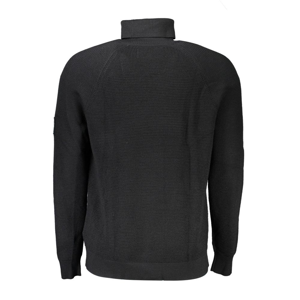 Pull homme Calvin Klein en laine noire, coupe classique, porté sur un mannequin dans une image de mode.