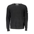 Pull homme en laine noire Calvin Klein, coupe classique, porté sur un fond neutre, détail du col et des manches.