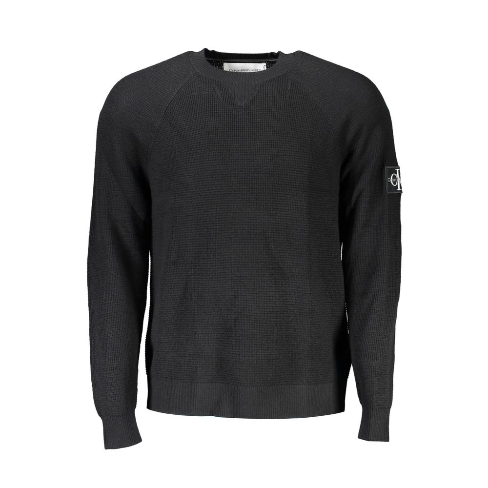 Pull homme en laine noire Calvin Klein, coupe classique, porté sur un fond neutre, détail du col et des manches.