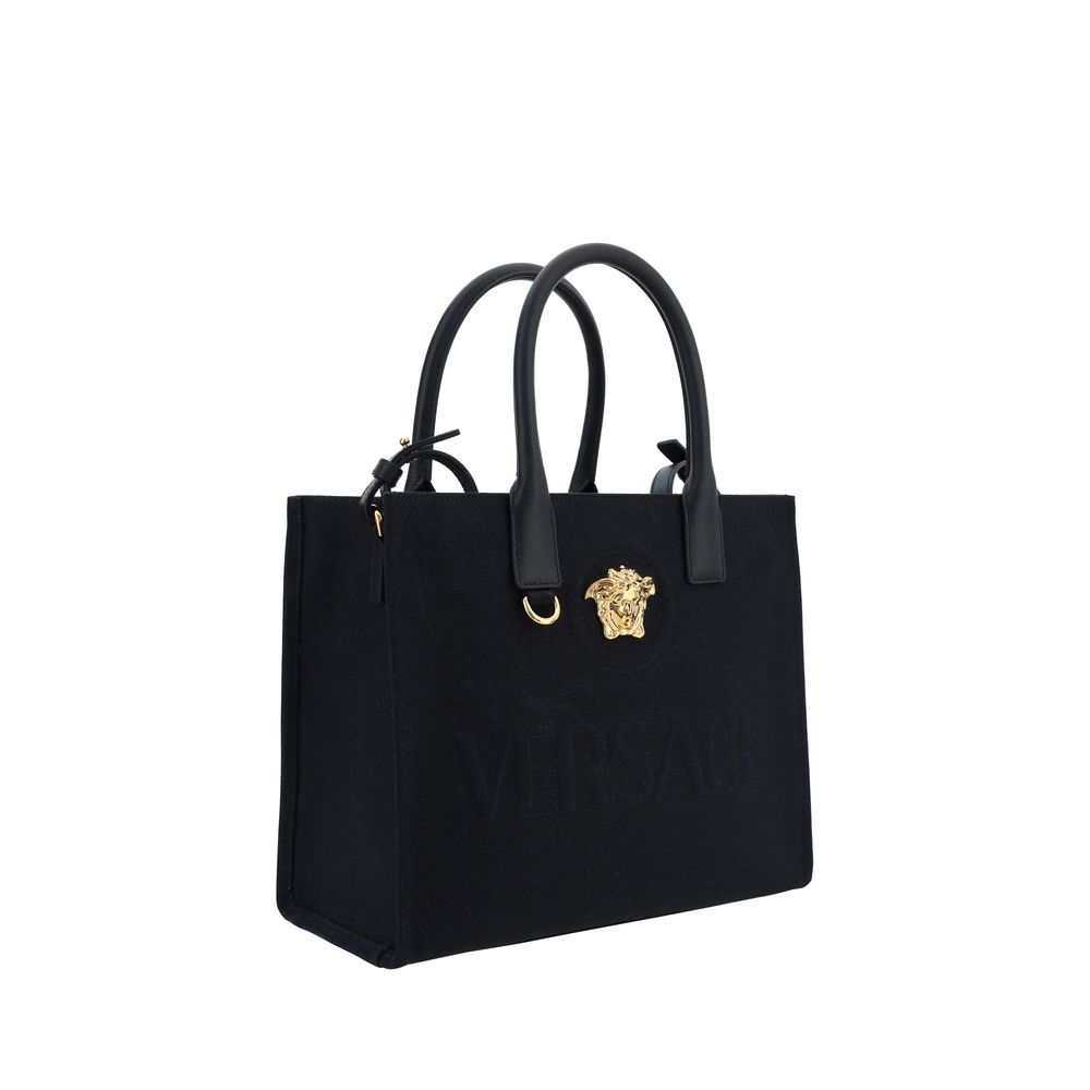 Sac à bandoulière noir en coton de Versace, avec logo distinctif, porté sur l'épaule.
