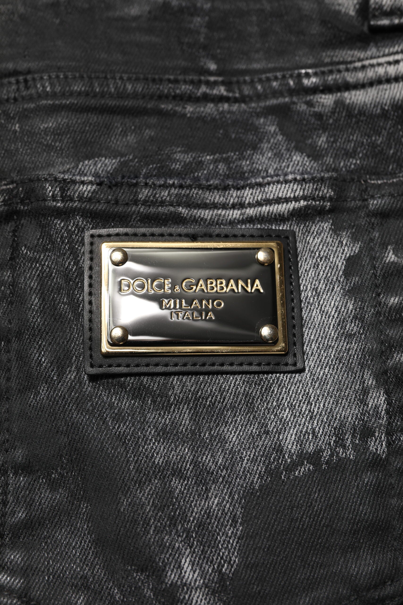 Jeans skinny en denim noir Dolce & Gabbana avec ourlet effacé et embellissements, denim lavé, mode élégante et moderne.