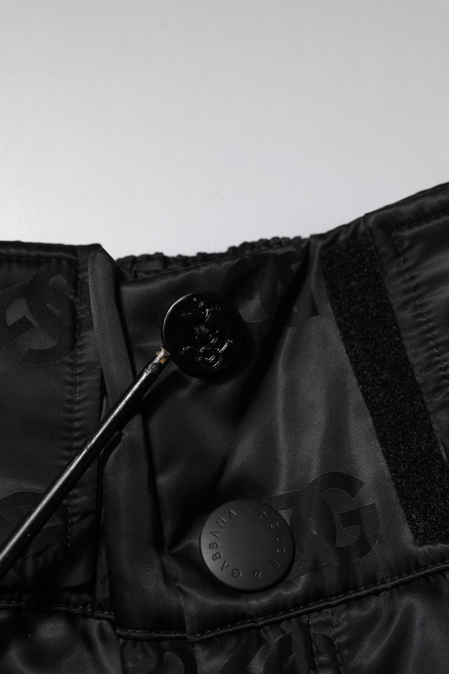 Pantalons droits en nylon noir Dolce & Gabbana avec logo DG visible, style élégant et moderne.