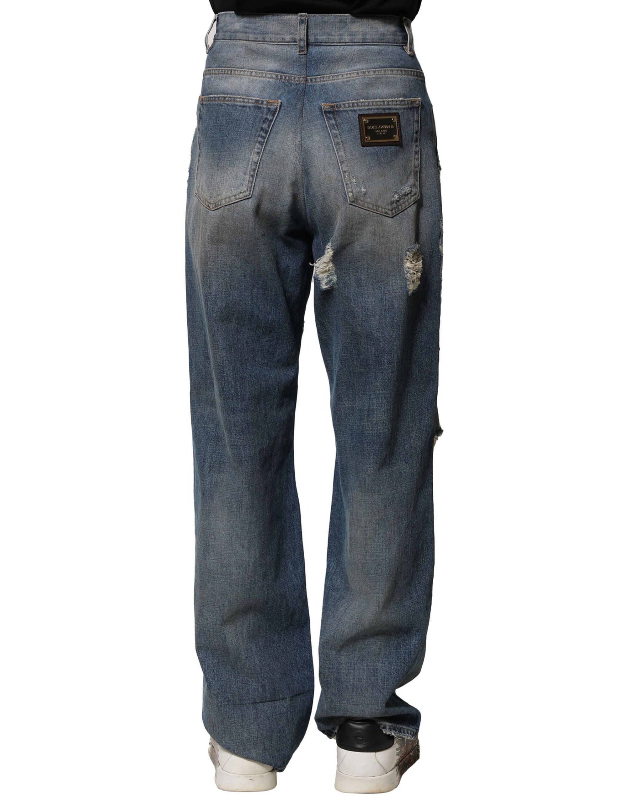 Jeans déchirés en coton bleu de Dolce & Gabbana pour homme, style décontracté avec détails usés.