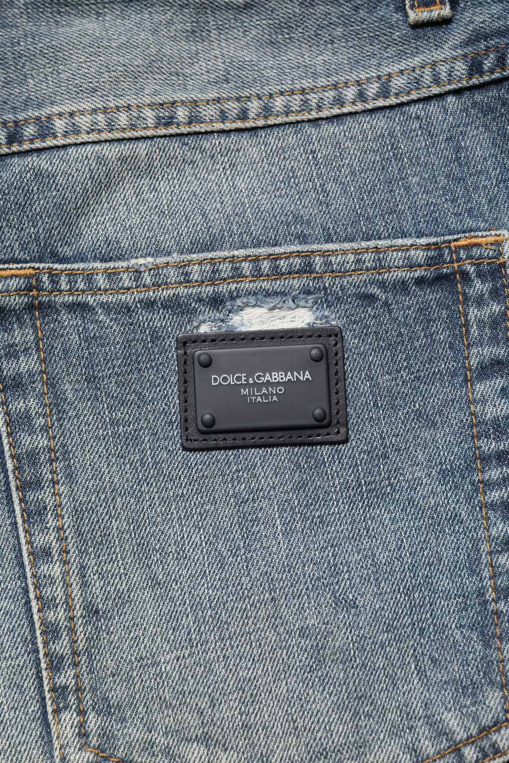 Jeans en denim bleu délavé et effiloché Dolce & Gabbana, coupe droite, style usé, look décontracté.