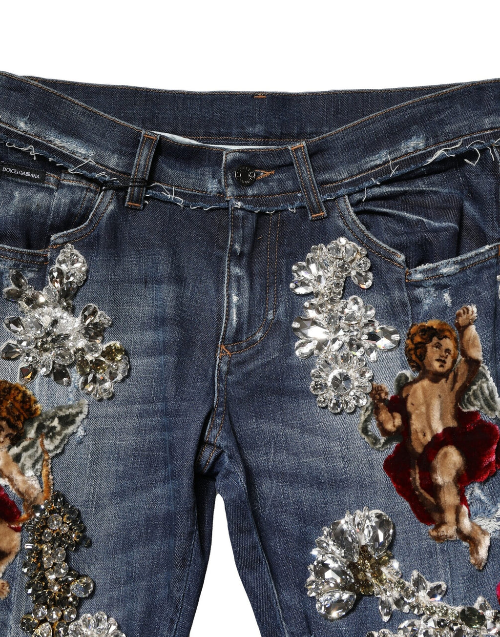Jeans en denim bleu Dolce & Gabbana avec embellissements en strass et coton, montrant la texture du tissu et les détails brillants.