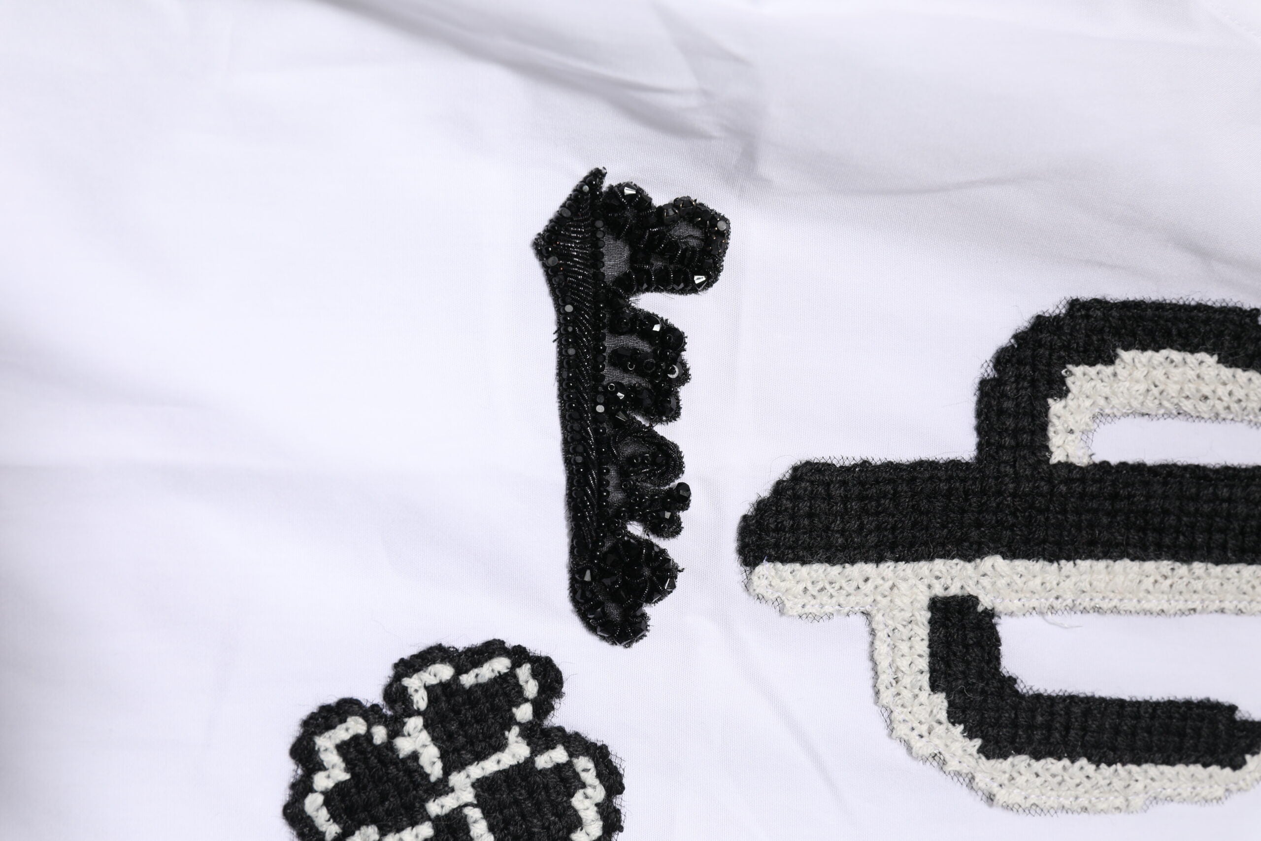Chemise blanche Dolce & Gabbana avec broderie dorée et détails élégants, en tissu finement travaillé.