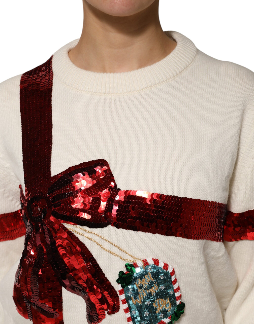 Pull à col rond blanc Dolce & Gabbana avec sequins, gros plan montrant les détails scintillants du pull.