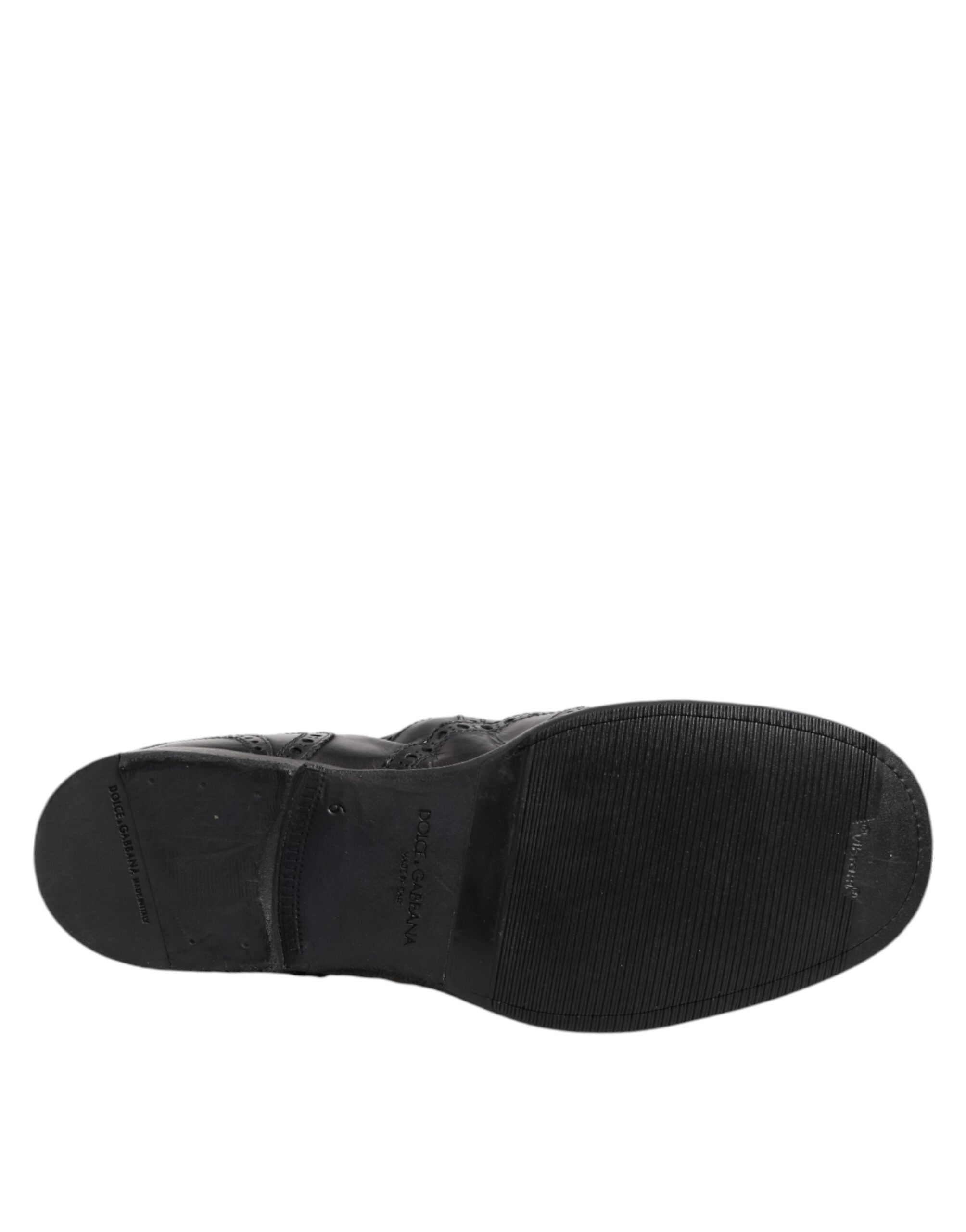 Bottes ankle en cuir noir Dolce & Gabbana, chaussures à enfiler élégantes et modernes, visibles en gros plan sur fond neutre.