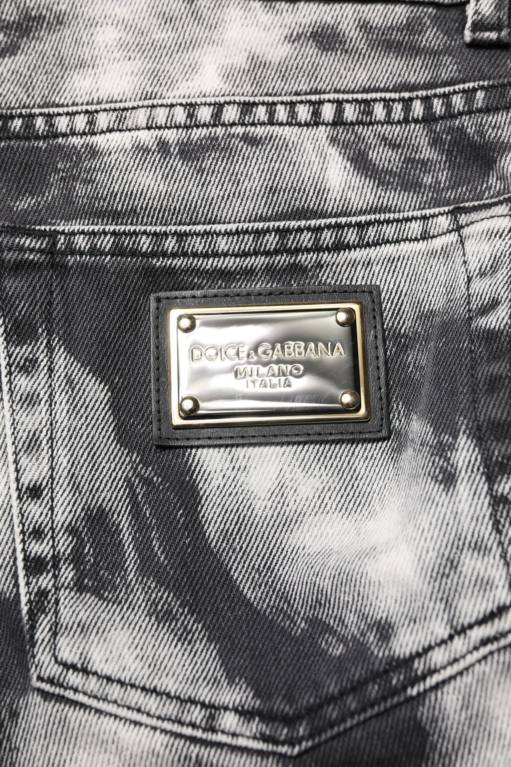 Jeans droits en denim tie-dye noir de Dolce & Gabbana, style décontracté et tendance, visibles avec détails de la texture et la coupe.