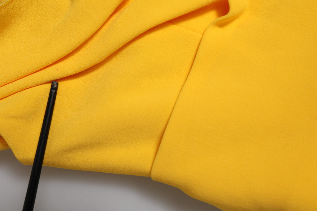 Robe de soirée jaune à une épaule de Dolce & Gabbana, coupe ajustée avec fente latérale élégante, en tissu fluide.