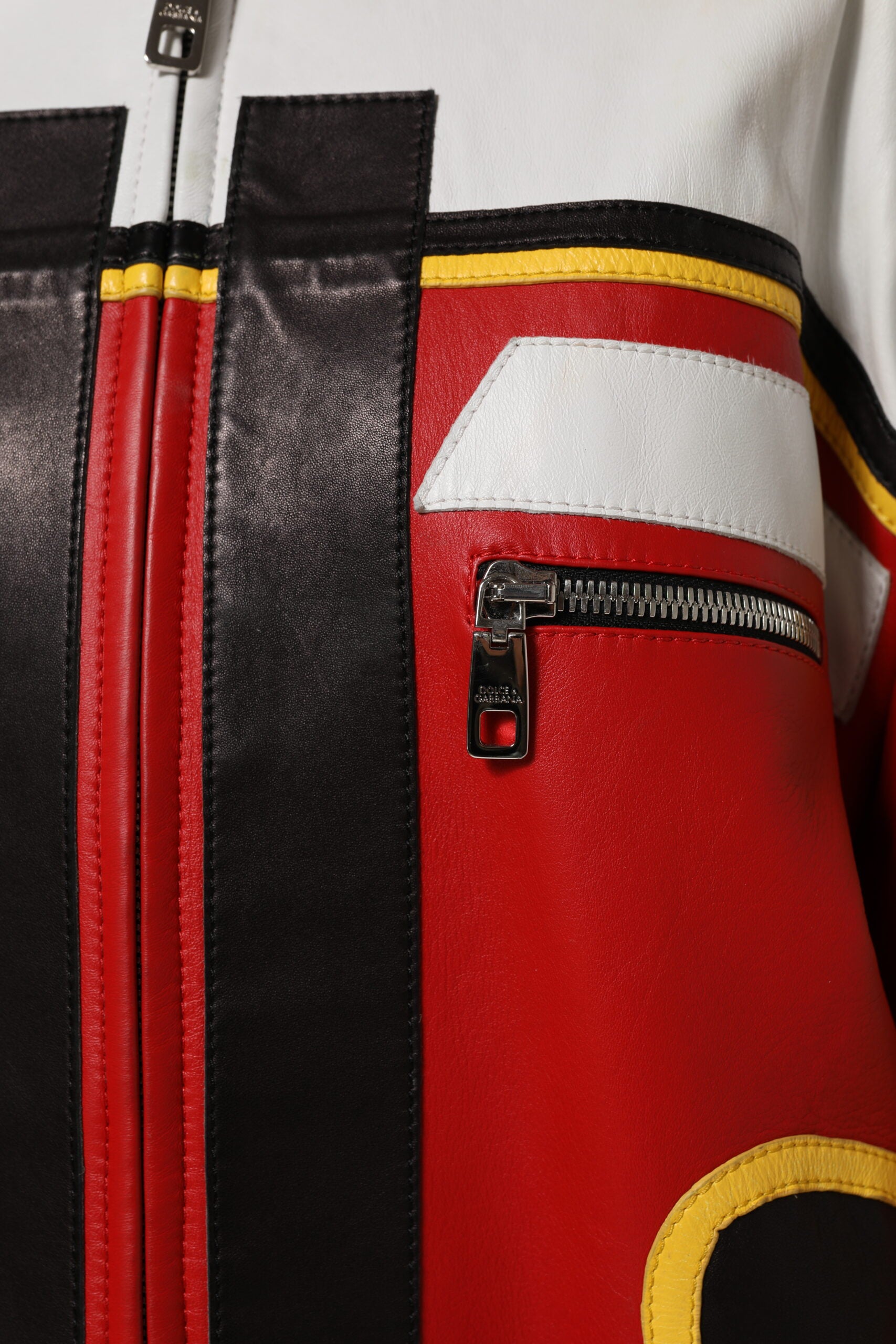 Veste en cuir multicolore Dolce & Gabbana, perfecto biker à zip complet, visible avec détails colorés et style audacieux.