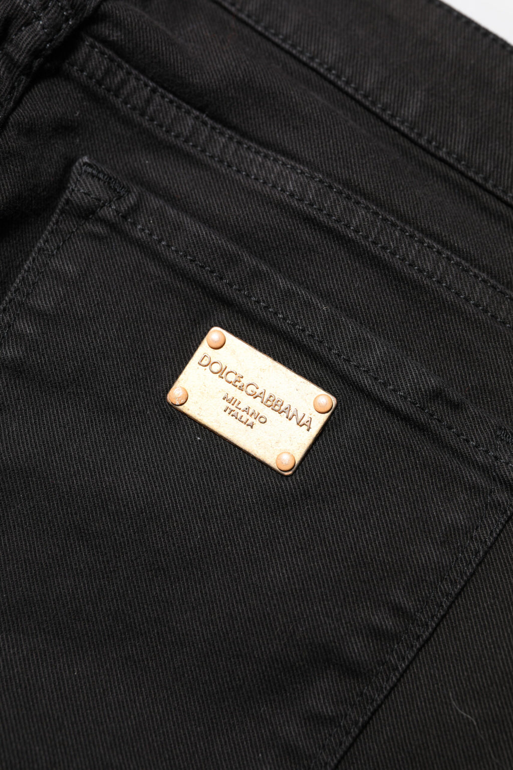 Jeans slim en coton noir Dolce & Gabbana, taille mi-haute, denim ajusté et tendance, visible sur la photo.