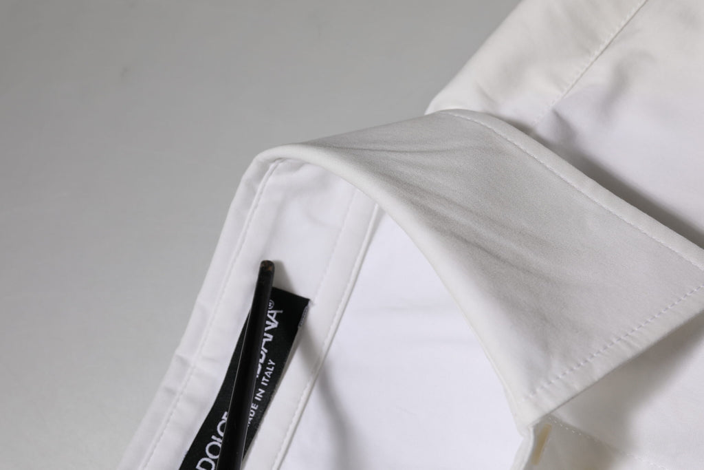 Chemise blanche Dolce & Gabbana en coton à col et manches longues, élégante et confortable, visible en détail dans l'image.