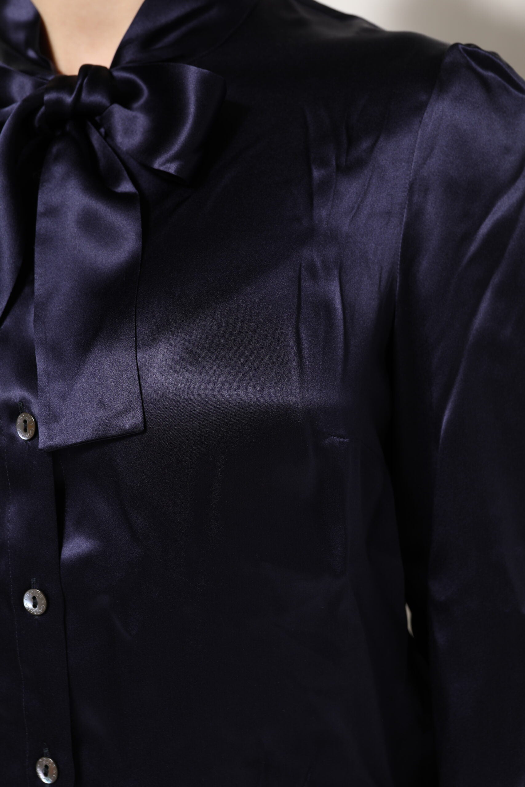 Chemisier en soie noire violette Dolce & Gabbana avec col ascot et fermeture élégante, détails sophistiqués et tissu luxueux.