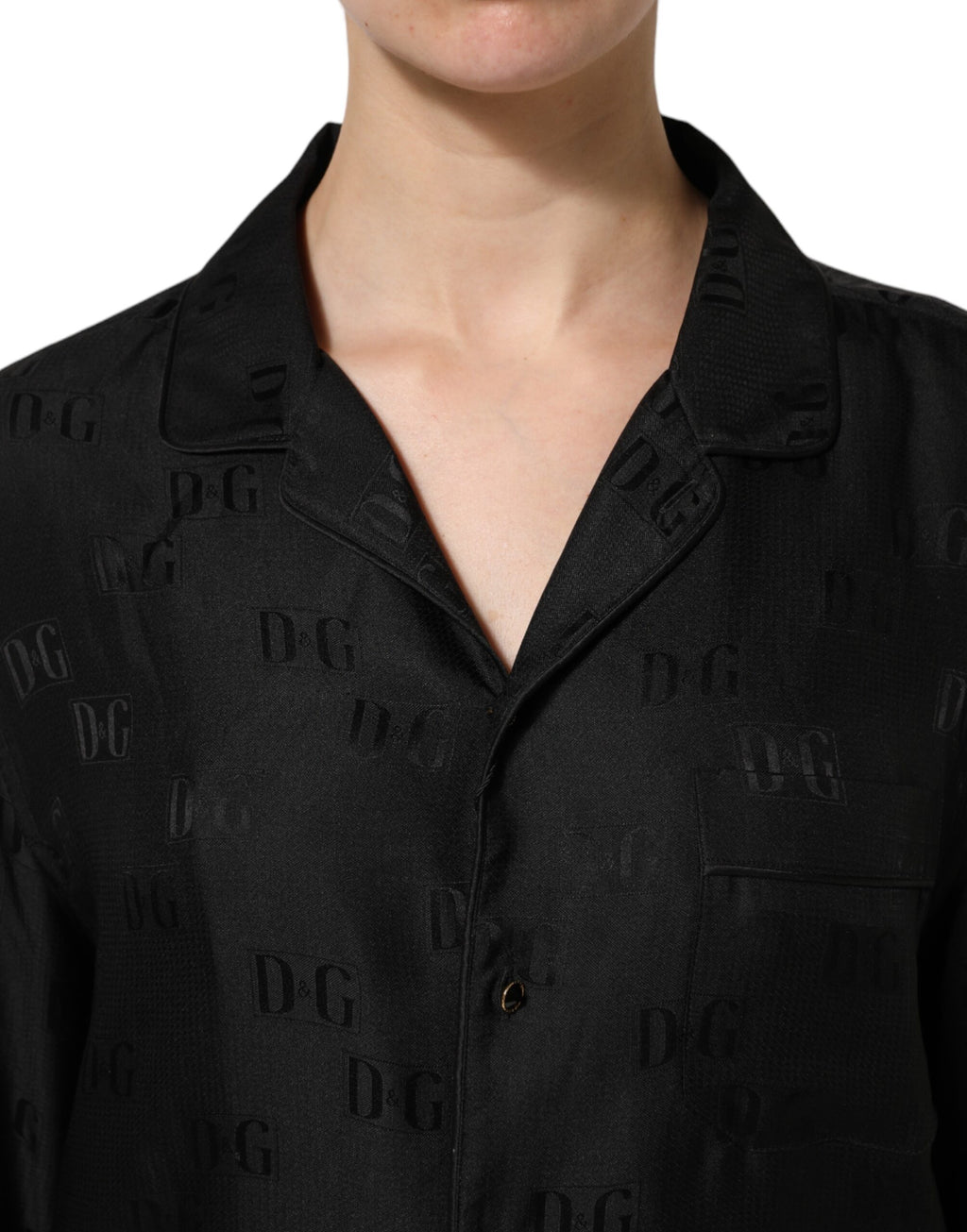 Top noir en soie Dolce & Gabbana avec broderie DG à manches longues, élégance et luxe sophistiqués.