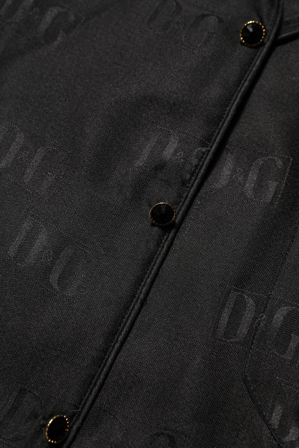 Haut en soie noire Dolce & Gabbana avec broderies DG à manches longues, élégant et sophistiqué.