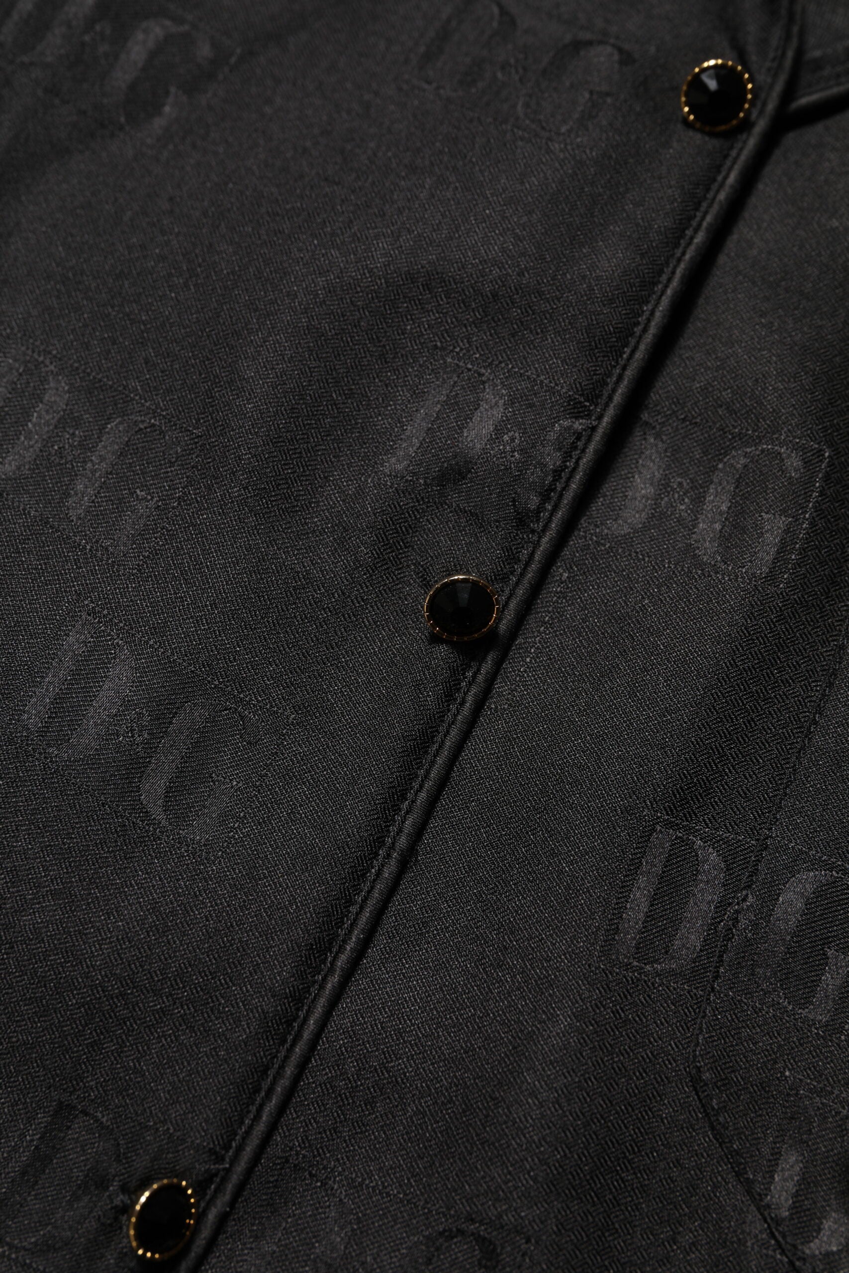 Haut en soie noire Dolce & Gabbana avec broderies DG à manches longues, élégant et sophistiqué.