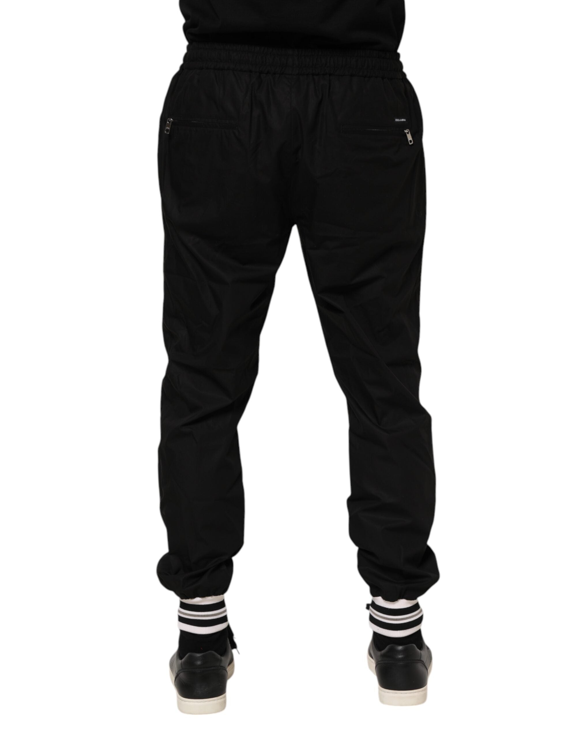 Pantalons jogger pour homme Dolce & Gabbana en coton noir avec bande logo, style décontracté et élégant.
