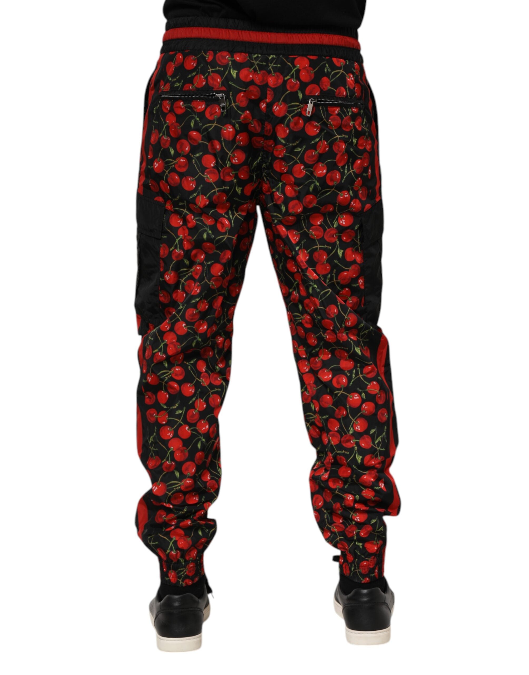 Pantalon de survêtement noir et rouge Dolce & Gabbana pour homme avec motif cerises, tissu confortable et style décontracté.
