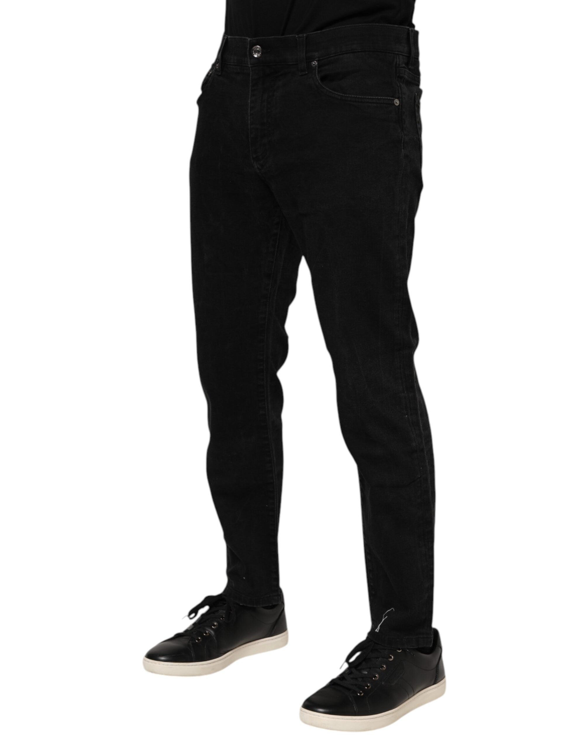 Jeans slim en denim noir Dolce & Gabbana avec plaque logo en coton, visibles détails de la coupe et de la texture du tissu.
