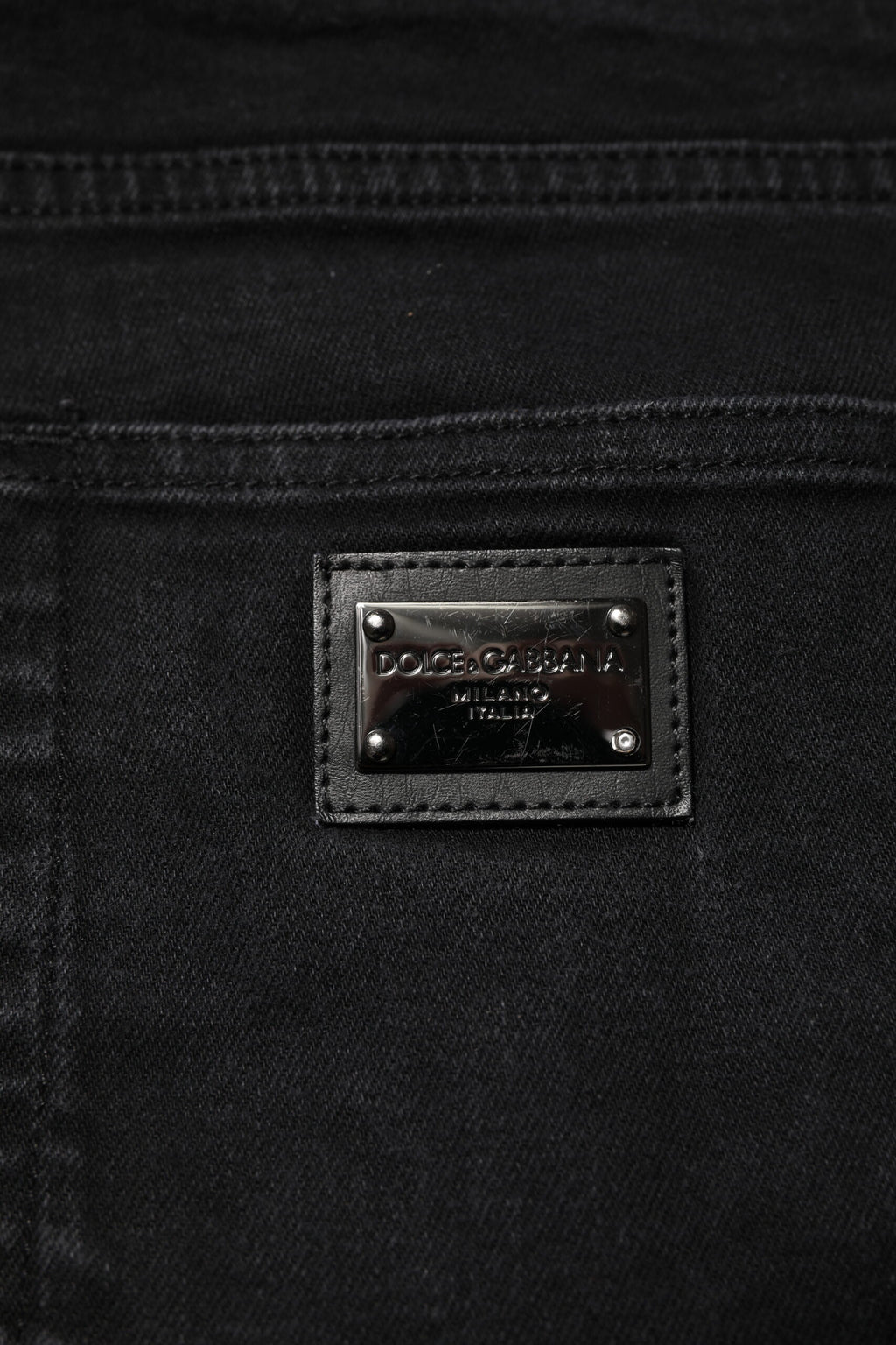 Jeans slim en denim noir Dolce & Gabbana avec plaque logo en coton, style moderne et ajusté.