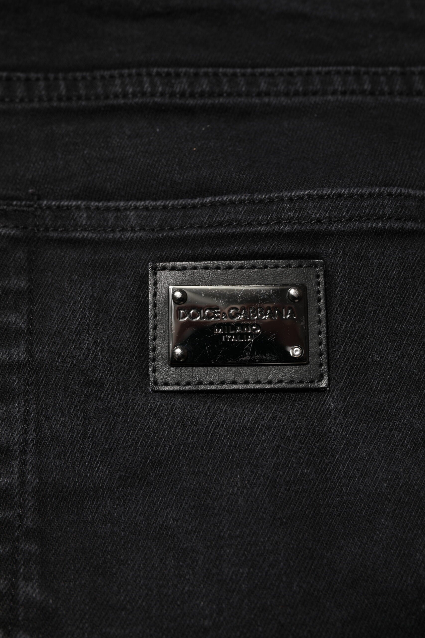 Jeans slim en denim noir Dolce & Gabbana avec plaque logo en coton, style moderne et ajusté.