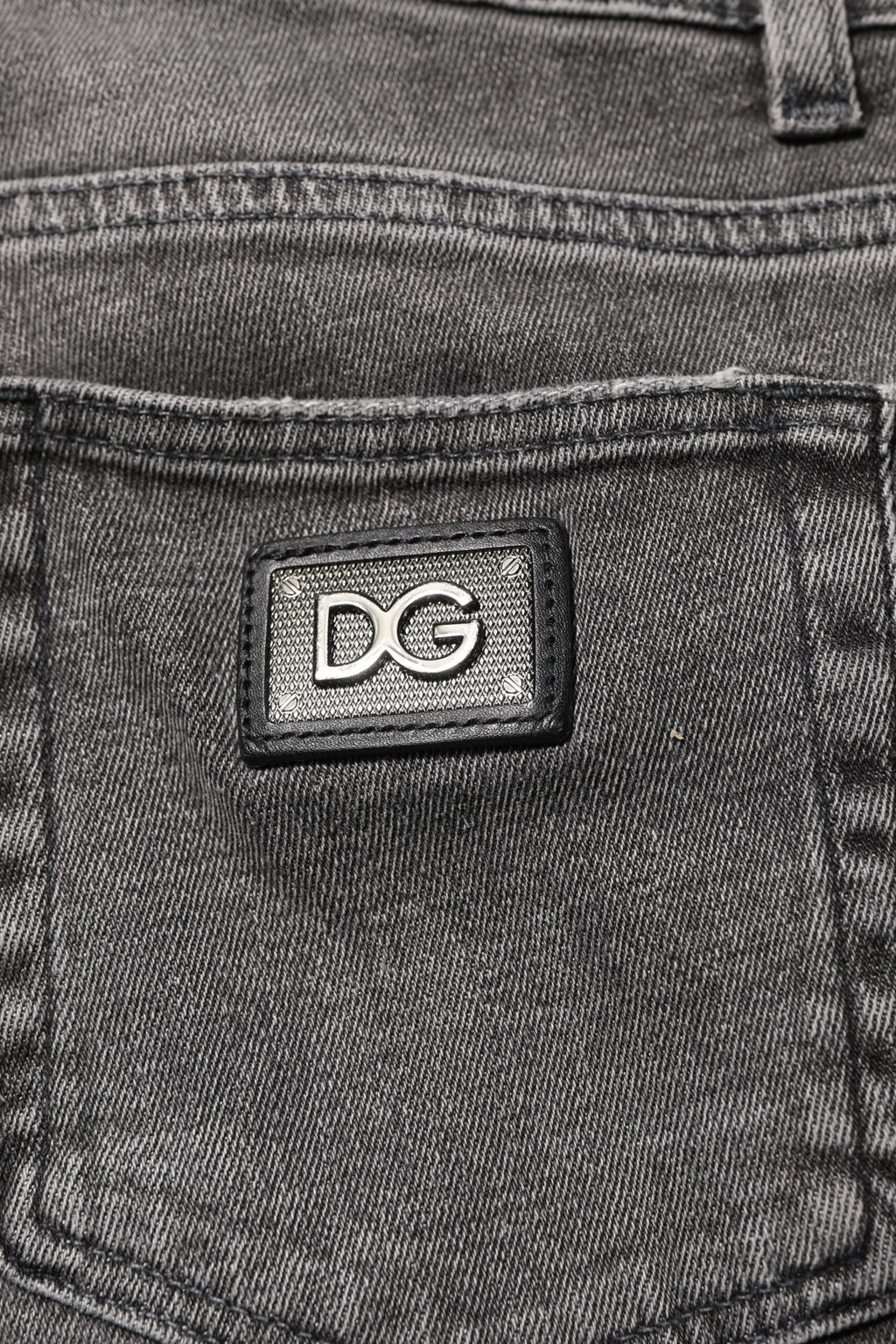 Jeans homme en denim gris Dolce & Gabbana avec plaque logo en coton, style décontracté et moderne.